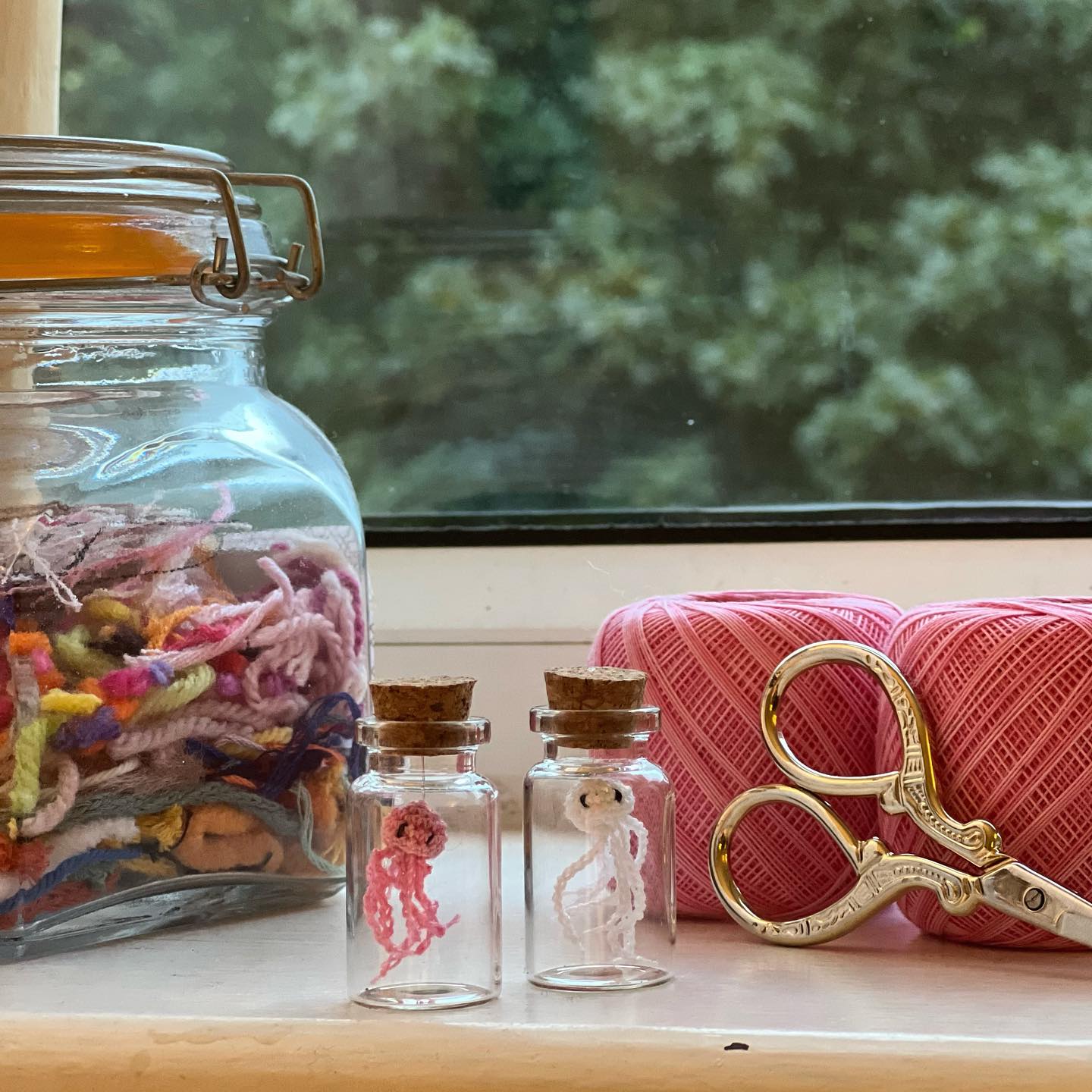 table with tiny jellyfish crochet toys in jars
